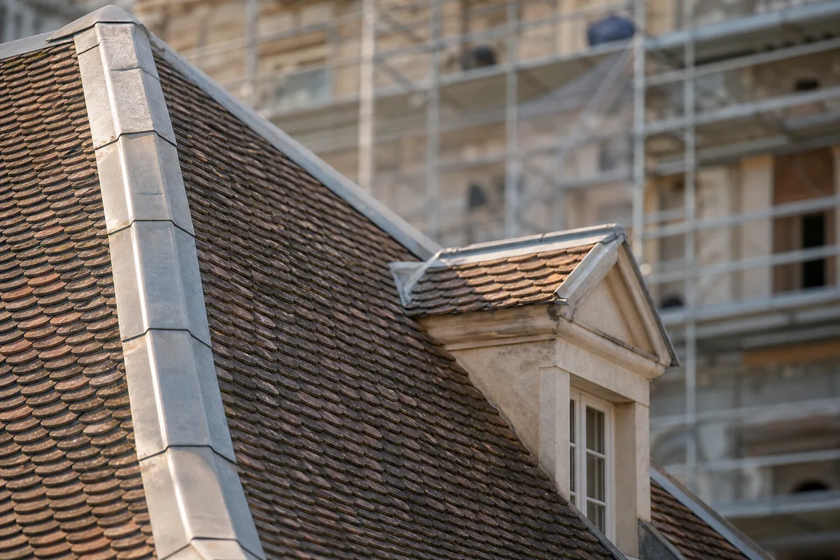 Toiture à forte pente en tuile écaille d’une maison bourgeoise de l’ouest lyonnais avec lucarnes maçonnées